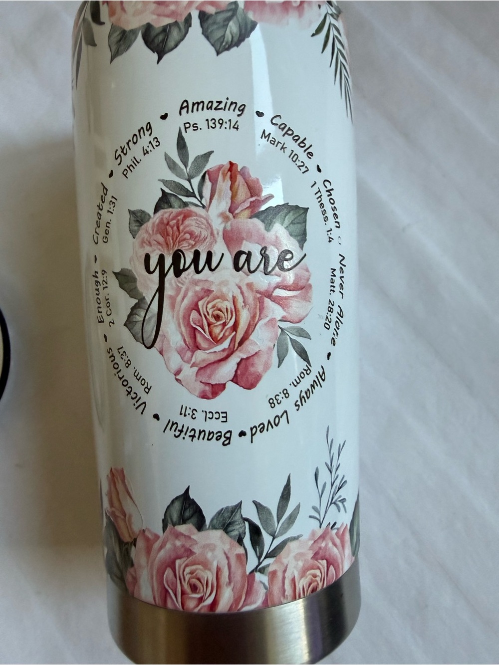 A 20oz Christian Bible Verse Stainless Steel Tumbler decorated with roses